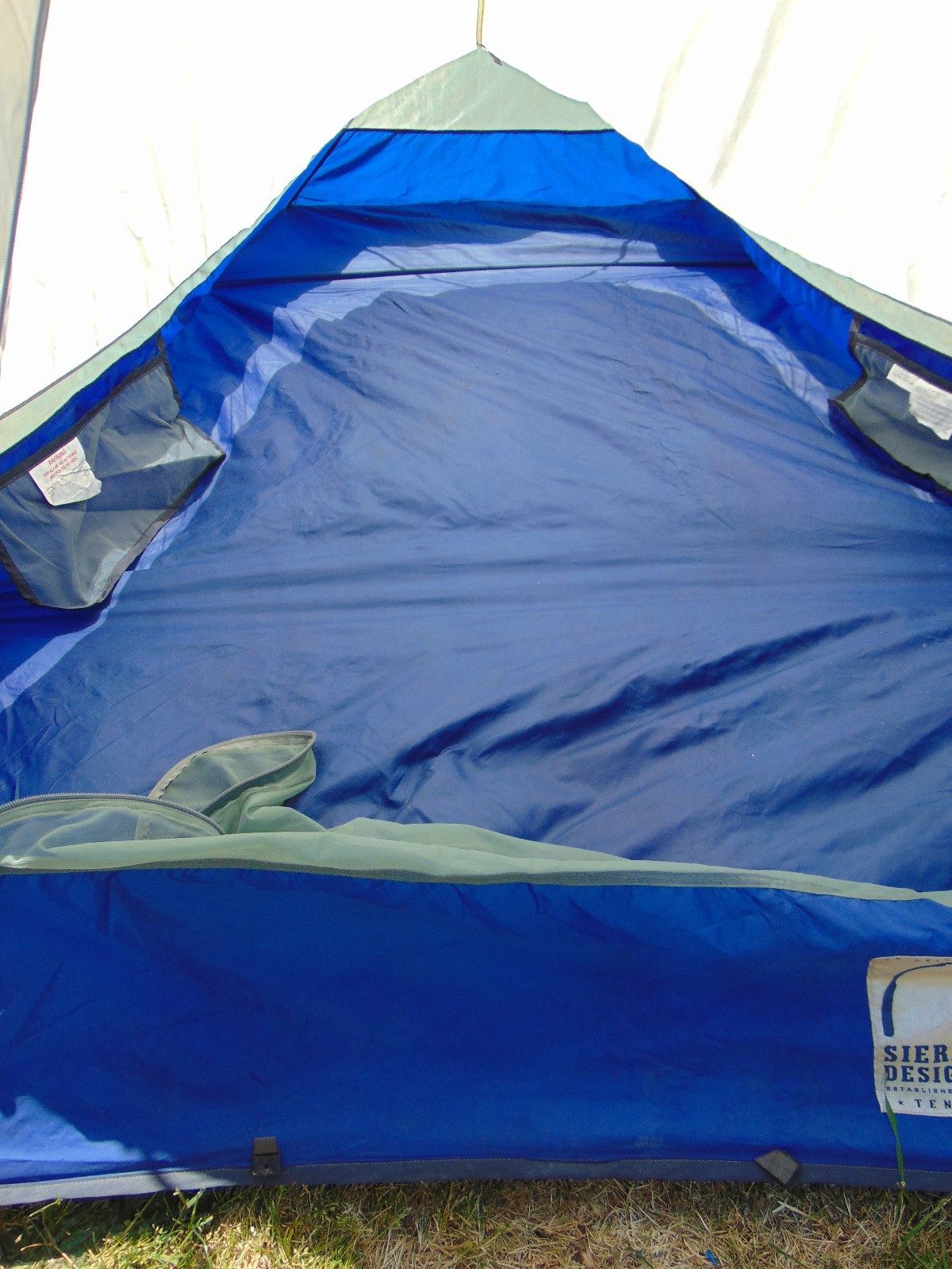 Inside the Clip Flashlight CD: navy bathtub floor, mesh gear pockets and the Sierra Designs label at the door